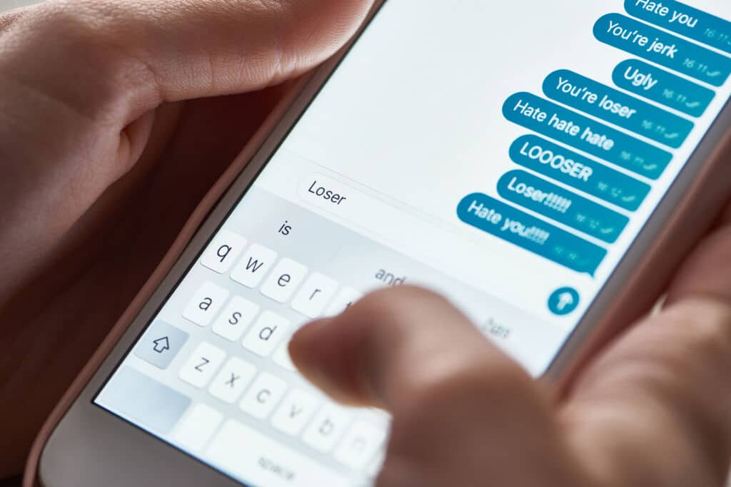 Forensic examiner connecting a smartphone to a workstation to recover deleted text messages