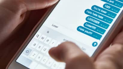 Forensic examiner connecting a smartphone to a workstation to recover deleted text messages